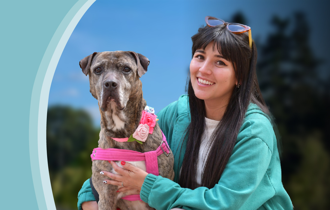 foto de perrita mirando al frente con mujer abrazándola 