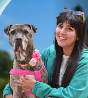 foto de perrita mirando al frente con mujer abrazándola 